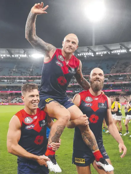  ??  ?? Melbourne’s Nathan Jones gets chaired off the MCG after playing game 300. Picture: Michael Klein