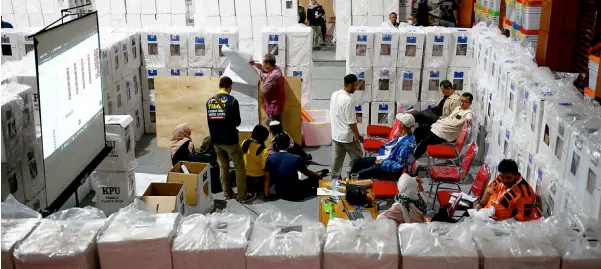  ?? — AFP photo ?? General Election Commission (KPU) officials and parties’ witnesses carry out a sub-district level recapitula­tion of the tabulation results from the polling stations in Jakarta.