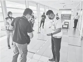  ??  ?? JALANKAN TUGAS: Pegawai dan anggota polis memeriksa dokumen individu yang memasuki Bintulu melalui penerbanga­n domestik di Lapangan Terbang Bintulu.