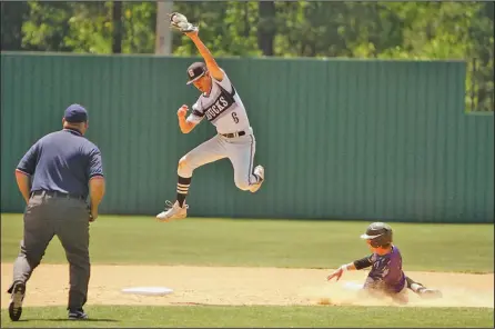  ?? Terrance Armstard/News-Times ?? Big ups: Smackover's Weston Smith climbs the ladder to snag a high throw as Fouke's Gabe Parker slides toward second base. The Bucks blasted the Panthers 14-1 Friday in the regional tournament at Smackover.