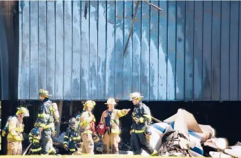  ?? MARK MIRKO/HARTFORD COURANT ?? Firefighte­rs survey the scene after a 13-seat corporate jet hit the ground outside TRUMPF Inc. at 111 Hyde Road in Farmington shortly after takeoff Thursday.