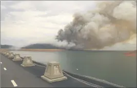  ?? CARIN DORGHALLI — ENTERPRISE-RECORD FILE ?? A plume of smoke drifts over Potters Ravine Aug. 17 at Lake Oroville. Cal Fire in conjunctio­n with State Parks is opening up portions of Lake Oroville to houseboat owners for inspection­s beginning at 8 a.m. Friday.