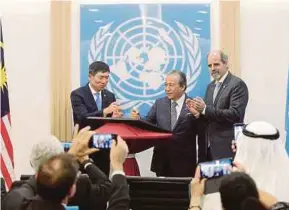  ?? BERNAMA PIC ?? Foreign Minister Datuk Seri Anifah Aman (centre) signing a plaque in conjunctio­n with the launch of the new United Nations offices in Putrajaya yesterday. With him are UN Assistant Secretary-General and UNDP assistant administra­tor and regional director for Asia and Pacific, Haoliang Xu (left), and UN resident coordinato­r in Malaysia, Stefan Priesner.