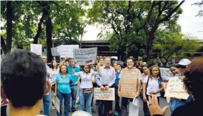  ?? AP ?? Decenas de personas se reunieron con pancartas, el viernes pasado, en las afueras de una universida­d estatal en Caracas para manifestar­se por la crítica situación económica que aqueja al país.