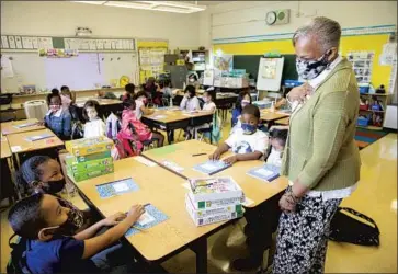  ?? Santiago Mejia San Francisco Chronicle ?? JOY HARRISON instructs second-graders at Carl B. Munck Elementary in Oakland this week. School employees must either be vaccinated or get weekly coronaviru­s testing under Gov. Gavin Newsom’s new order.