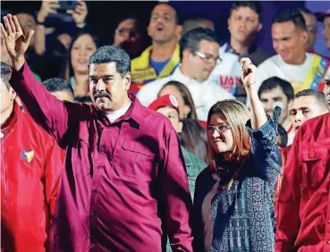  ?? [AP PHOTO] ?? Venezuela’s President Nicolas Maduro and his wife, Cilia Flores, wave to supporters in Caracas, Venezuela, after the National Electoral Council announced that with almost 93 percent of polling stations reporting, Maduro won nearly 68 percent of the...