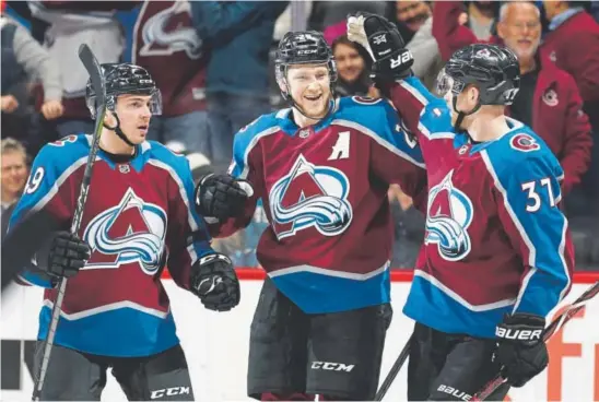  ?? Joe Mahoney, The Associated Press ?? From left, Samuel Girard, Nathan MacKinnon and J.T. Compher celebrate MacKinnon’s second goal of Thursday night’s game.