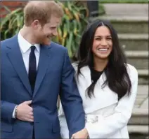  ?? CHRIS JACKSON, GETTY IMAGES ?? Prince Harry and Meghan Markle talk to media at The Sunken Gardens at Kensington Palace on Monday after announcing their engagement. Markle’s coat was designed by LINE The Label, a brand based in Toronto. MAIJA KAPPLER