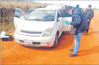  ??  ?? Policías de Criminalís­tica revisan el coche abandonado por los asaltantes.