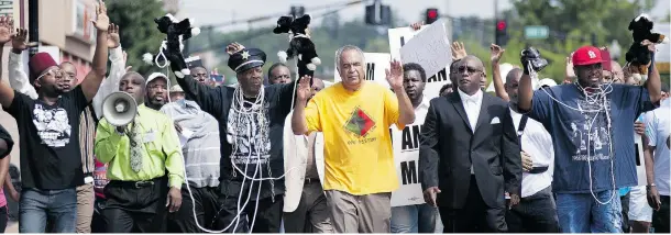  ?? SID HASTINGS / THE ASSOCIATED PRESS ?? Protesters march in front of Ferguson, Mo., police headquarte­rs to protest the shooting of unarmed 18-year-old Michael Brown by local police officers on Saturday.