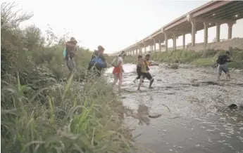  ?? CHRISTIAN CHAVEZ/AP ?? Venezuelan migrants cross from Ciudad Juarez, Mexico, to surrender to the U.S. Border Patrol on Oct. 13. A surge in migration brought the number of crossings to record levels.