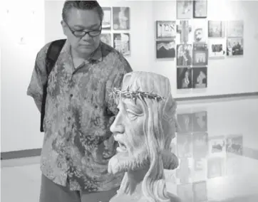  ?? PHOTO BY MIKE DE JUAN ?? THE FACE OF LOVE
A man takes a close look at an image of Jesus Christ during
the annual “Kristo” exhibit that features works on the passion of Christ. This year’s exhibit at
the SM Megamall in Mandaluyon­g
City is titled “Aman,” which means...