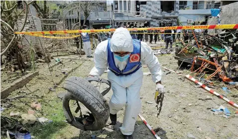  ?? | Reuters ?? A MEMBER of the Counter Terrorism Department collects evidence at the scene of a deadly explosion in a residentia­l area in Lahore, Pakistan, yesterday.