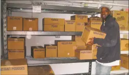  ??  ?? Daryl Fleming, residentia­l monitor at the F.I.S.H. shelter in Torrington, assists in organizing the cases of food donated by the nonprofit sponsorshi­p of the Torrington Woman’s Club on behalf of the Church of Jesus Christ Latter Day Saints.