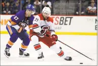  ?? Julio Cortez / Associated Press ?? Hurricanes right wing Nino Niederreit­er, right, skates with the puck against Anders Lee of the Islanders during the third period of Sunday’s game in New York.