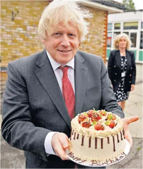  ?? ?? Having his cake: Boris Johnson presented with a birthday treat during a school visit on June 19 2020 – the same day for which he received a ‘party’ fine