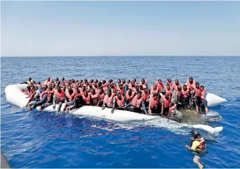  ??  ?? Migrants being rescued from a dinghy off the Libyan coast in the internatio­nal waters between Malta and Libya. AFP/Italian Red Cross/Yara Nardi