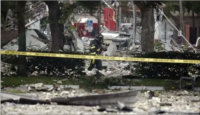  ?? BRYNN ANDERSON — THE ASSOCIATED PRESS ?? A firefighte­r walks through the remains of a building after an explosion injured 21people on Saturday in Plantation, Fla.