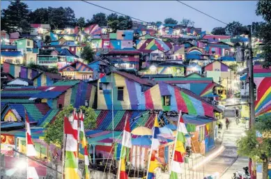  ?? SURYO WIBOWO / AGENCE FRANCE-PRESSE ?? “The rainbow village” in Semarang, Indonesia, has become an internet sensation and is attracting hordes of visitors.