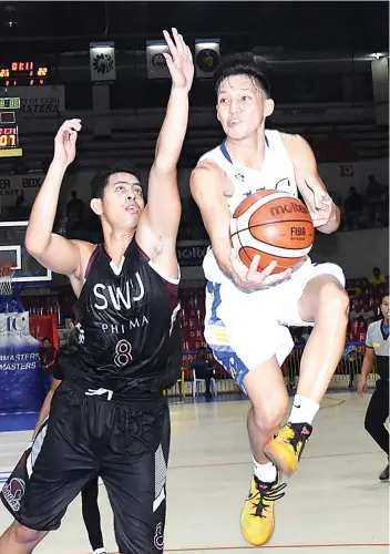  ?? SUNSTAR FOTO / RUEL ROSELLO ?? COBRA BLOCK.
Kishimoto Kei Ya Andre (13) of the UC Webmasters drives the ball against SWU’s defense during the senior game of the Cesafi at the Cebu Coliseum.