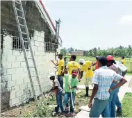  ?? PHOTO BY GARETH DAVIS ?? Some of the volunteers giving a face-lift to a building occupied by the Portland Football Associatio­n at Carder Park in the parish.