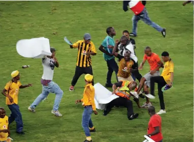  ?? PICTURE: MOTSHWARI MOFOKENG/AFRICAN NEWS AGENCY (ANA) ?? VIOLENT CONDUCT: A security official is beaten by a mob at the Moses Mabhida Stadium in Durban. Fans stormed the pitch and attacked PSL staff and destroyed property.