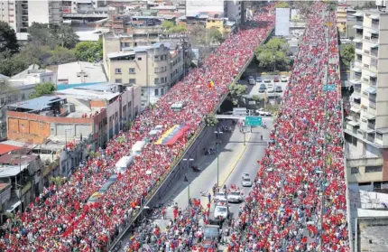  ??  ?? Durante siete horas, la marea roja despidió los restos de Chávez en las calles de Caracas