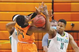  ?? SUE OGROCKI/ASSOCIATED PRESS ?? Baylor forward Flo Thamba, left, and guard Mark Vital (11) knock the ball away from Oklahoma State guard Bryce Williams (14) in the first half of their game Saturday.