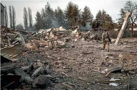  ?? AP ?? A Ukrainian Territoria­l Defence Forces volunteer makes his way through the debris of a car wash destroyed by Russian bombing in Baryshivka, east of Kyiv, yesterday. After more than two weeks of war, the Russian military is still advancing very slowly, and at a heavy cost, raising questions about how the conflict will unfold.