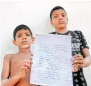  ??  ?? Manjula's two sons with a copy of the anonymous letter the famil received