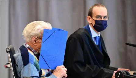  ?? AFP ?? El acusado Josef Schutz, de 100 años de edad, esconde su rostro detrás de una carpeta en el juicio, en Brandenbur­g an der Havel, noreste de Alemania, este jueves.