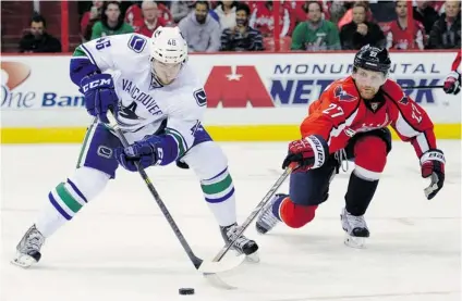  ?? NICK WASS/ THE ASSOCIATED PRESS ?? Capitals defenceman Karl Alzner, right, vies for the puck against Canucks left winger Nicklas Jensen during the second period of their game in Washington, D. C. on Friday . Though the Canucks lost 4- 3, Jensen looks increasing­ly like he actually...