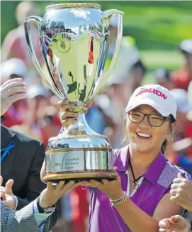  ?? ED KAISER/POSTMEDIA NEWS ?? Lydia Ko of New Zealand raises her trophy after winning the CN Canadian Women’s Open in Edmonton on Sunday. The Korean-born golfer shot a final-round, six-under-par 64.