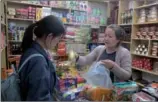  ??  ?? Penpa Dekyi, an evacuee of Dram township in Nyalam county, runs a grocery to sell products from Nepal and India in the Dram Shopping Mall in Xigaze.