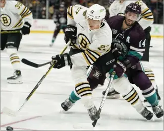  ?? RYAN SUN — THE ASSOCIATED PRESS ?? Bruins defenseman Hampus Lindholm, center front, controls the puck against Ducks center Adam Henrique.