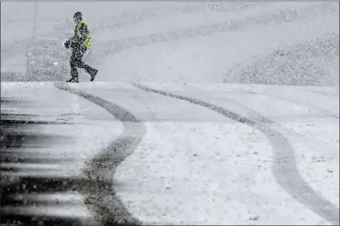  ?? WILL LESTER — THE ORANGE COUNTY REGISTER VIA AP ?? A pedestrian walks across the Highway 38overpass above I-15in the California Cajon Pass on Feb. 23, as heavy snow falls. The storm cell moved quickly through the area though more snow is in the forecast.