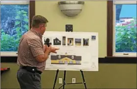  ??  ?? Chad Fowler, a spokesman for Stewart’s Shops, points out some of the historic designs that would be featured in the company’s proposed new location in the town of Brunswick during a Thursday night public hearing hosted by the town Planning Board.