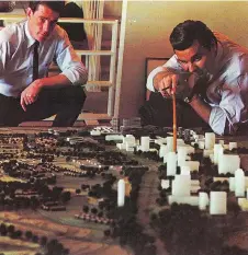  ??  ?? Bill Teron, right, points to a model of Kanata and, in particular, to a proposed town centre as Ian Johns looks on. Johns was the main architect on staff who worked with Teron in Kanata and for many years later.