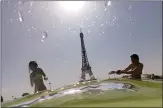  ?? DOMINIQUE FAGET AFP/GETTY IMAGES ?? People cool off at the Trocadero Fountains next to the Eiffel Tower in Paris on July 25 as a heat wave hits Europe.