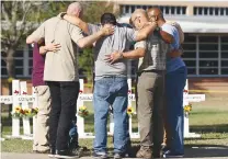  ?? KIN MAN HUI/THE SAN ANTONIO EXPRESS-NEWS VIA AP ?? Men form a prayer circle at a memorial site for the victims of the Robb Elementary School shooting, Thursday in Uvalde, Texas.