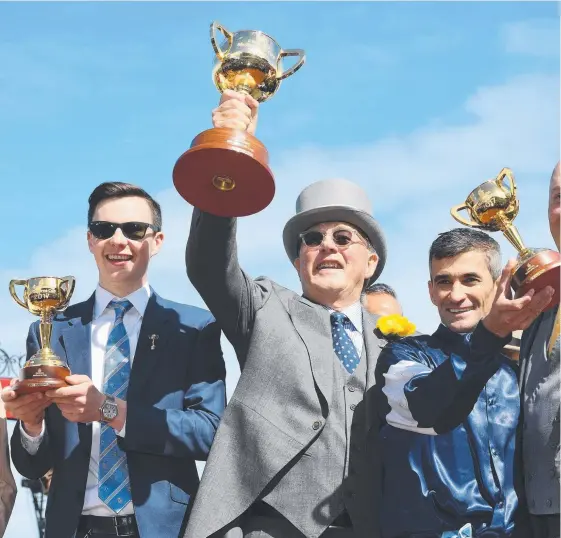  ?? Picture: AAP IMAGES ?? Lloyd Williams (centre with the Melbourne Cup he won last month) has got the attention of racing officials after his radio comments.