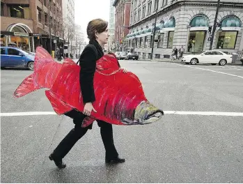  ?? GERRY KAHRMANN ?? Gwen Barlee carries a cardboard salmon after a protest outside the Department of Fisheries and Oceans in 2005. The respected environmen­tal activist died Thursday after a year-long fight with cancer.