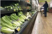  ?? MARK J. TERRILL — THE ASSOCIATED PRESS FILE ?? Romaine lettuce sits on the shelves as a shopper walks through the produce area of an Albertsons market in Simi Valley.