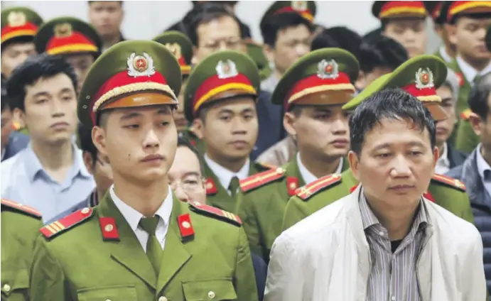  ?? ?? Uneseného Trinh Xuan Thanha (v strede) v Hanoji odsúdili na doživotie.