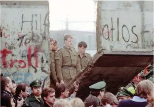  ?? ANSA ?? Le guardie della Ddr osservano i manifestan­ti abbattere un pezzo di Muro: è l’11 novembre 1989