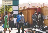  ?? ANNE MIMAULT / REUTERS ?? Relatives of victims of the attack wait outside
a morgue in Ouagadougo­u on Friday.