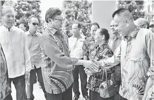  ??  ?? MUHIBAH: Abang Johari bersalaman dengan tetamu ketika mengadakan kunjungan Tahun Baharu Cina di kediaman Tiong (kiri) di Sibu, semalam.