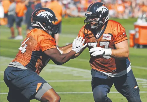  ?? Andy Cross, The Denver Post ?? Offensive tackle Justin Murray, left, and guard Allen Barbre do blocking drills at Broncos training camp Friday. Barbre was acquired Wednesday.