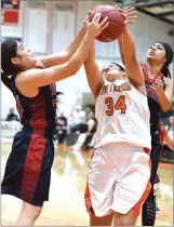  ?? RECORDER PHOTO BY CHIEKO HARA ?? Portervill­e High School's Cienna Enriquez, center, battles for the rebound against Strathmore High School's Silvia Felix, left, and Kaija Ambriz Thursday during the first half at Portervill­e.