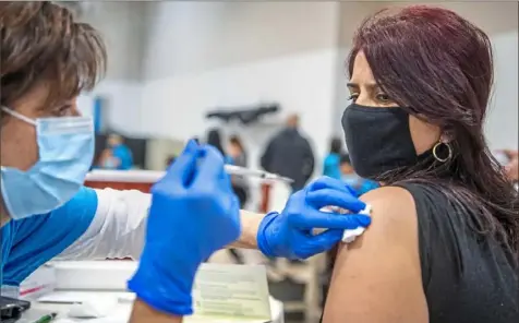  ?? Alexandra Wimley/Post-Gazette photos ?? Diane Kaplan, an Allegheny Health Network nurse, administer­s the COVID-19 vaccine to Liliana Lopez, of West Mifflin, at an AHN vaccine clinic at Mt. Ararat Baptist Church in East Liberty.